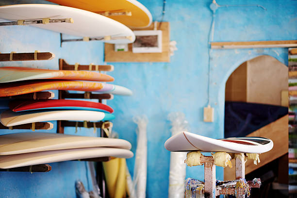 Colorful surfboards displayed on shelves in a workshop.