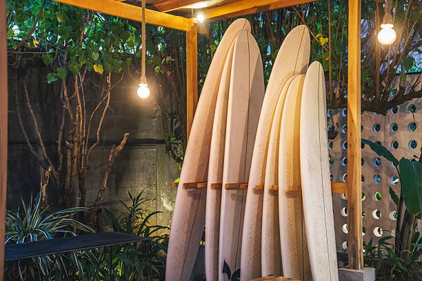 White surfboards neatly stored on a wooden rack in a charming tropical outdoor area.